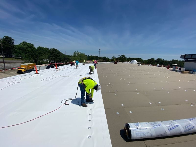 Engineers installing solar panels on a commercial flat roof